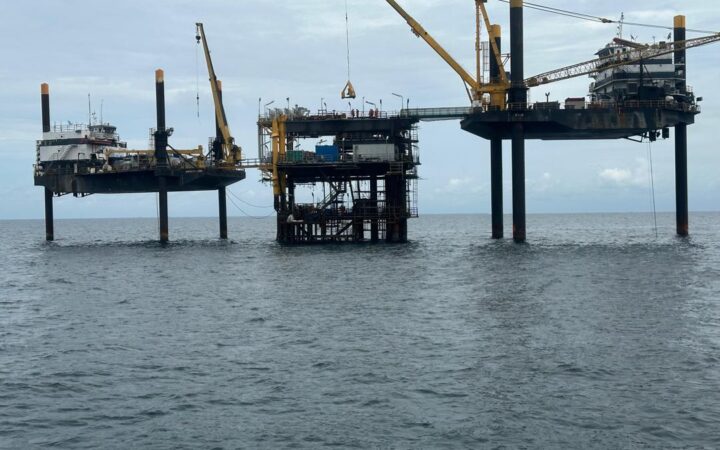 Jack-up vessels and cranes working alongside an offshore wellhead platform